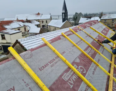 Pose d'écran sous-toiture et de liteaux sur une charpente